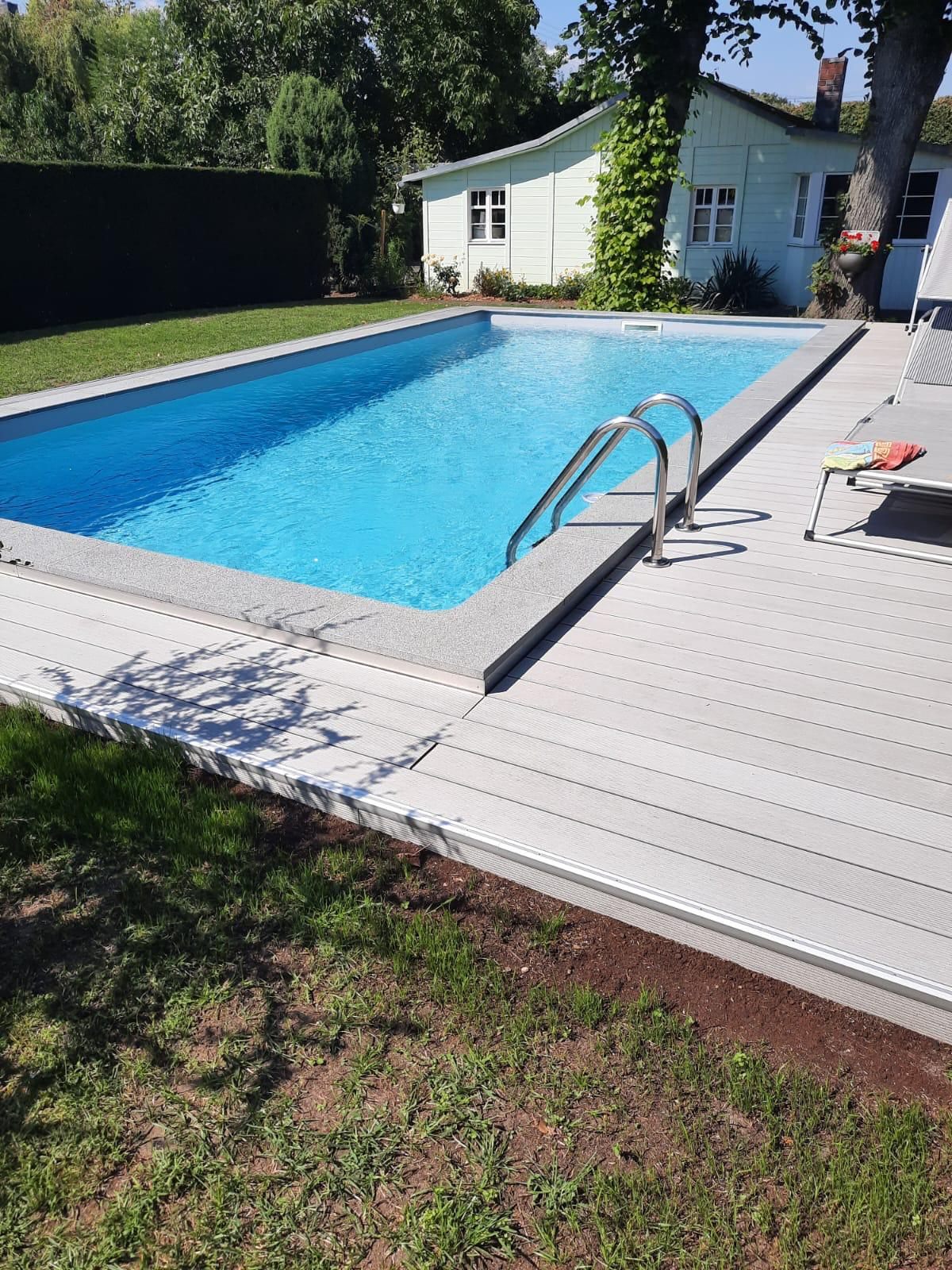 Pool nach der Sanierung mit Holzterrasse und neuem Wasser